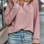 Kvinde i lyserød ribstrikket sweater med kort lynlås og rullekrave