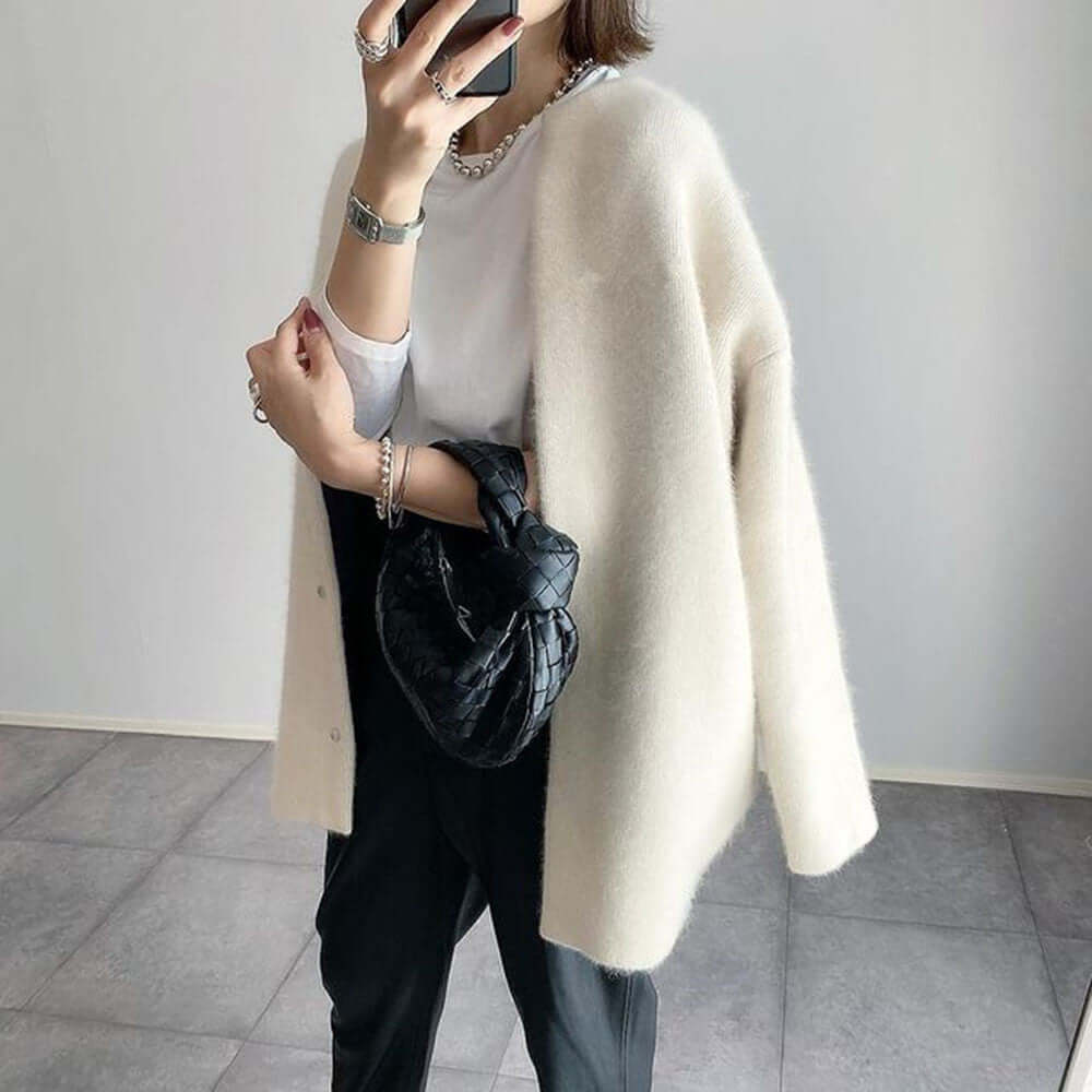 Dame i lang strikket cardigan med rund hals og knaplukning