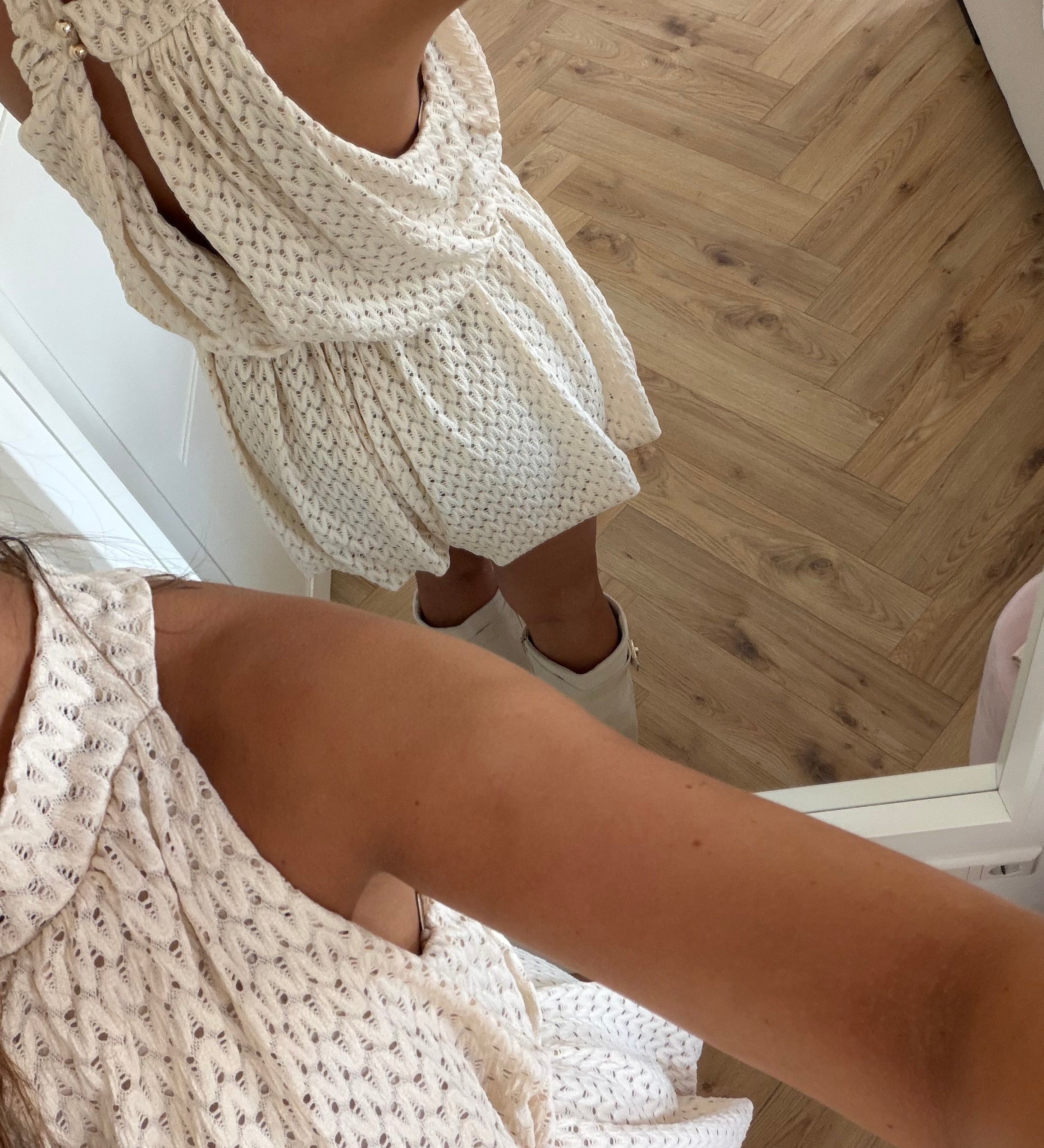 Creme jumpsuit med højhalset krave og struktureret mønster
