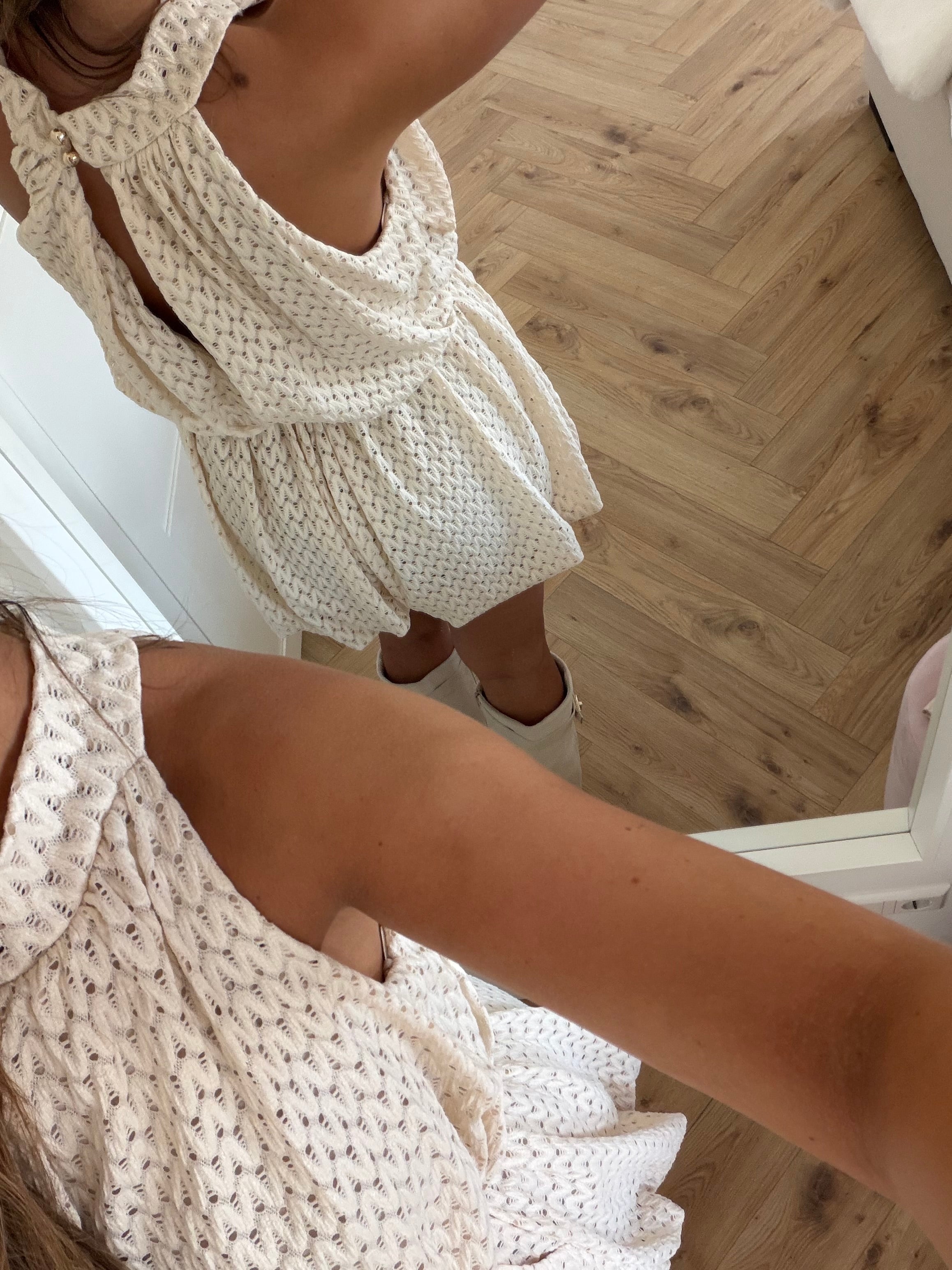 Creme jumpsuit med højhalset krave og struktureret mønster