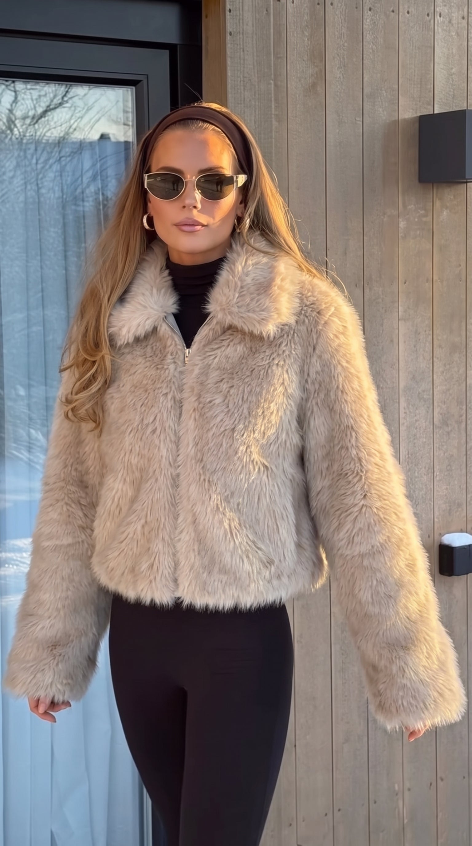 Dame i beige jakke i langhåret kunstpels med bred krave