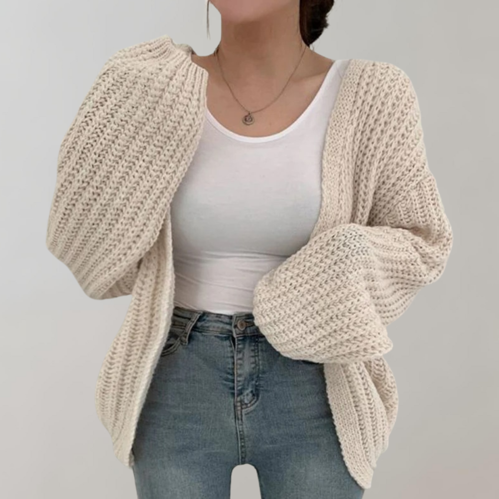 Dame i oversized strikcardigan med ribstruktur og lange ærmer