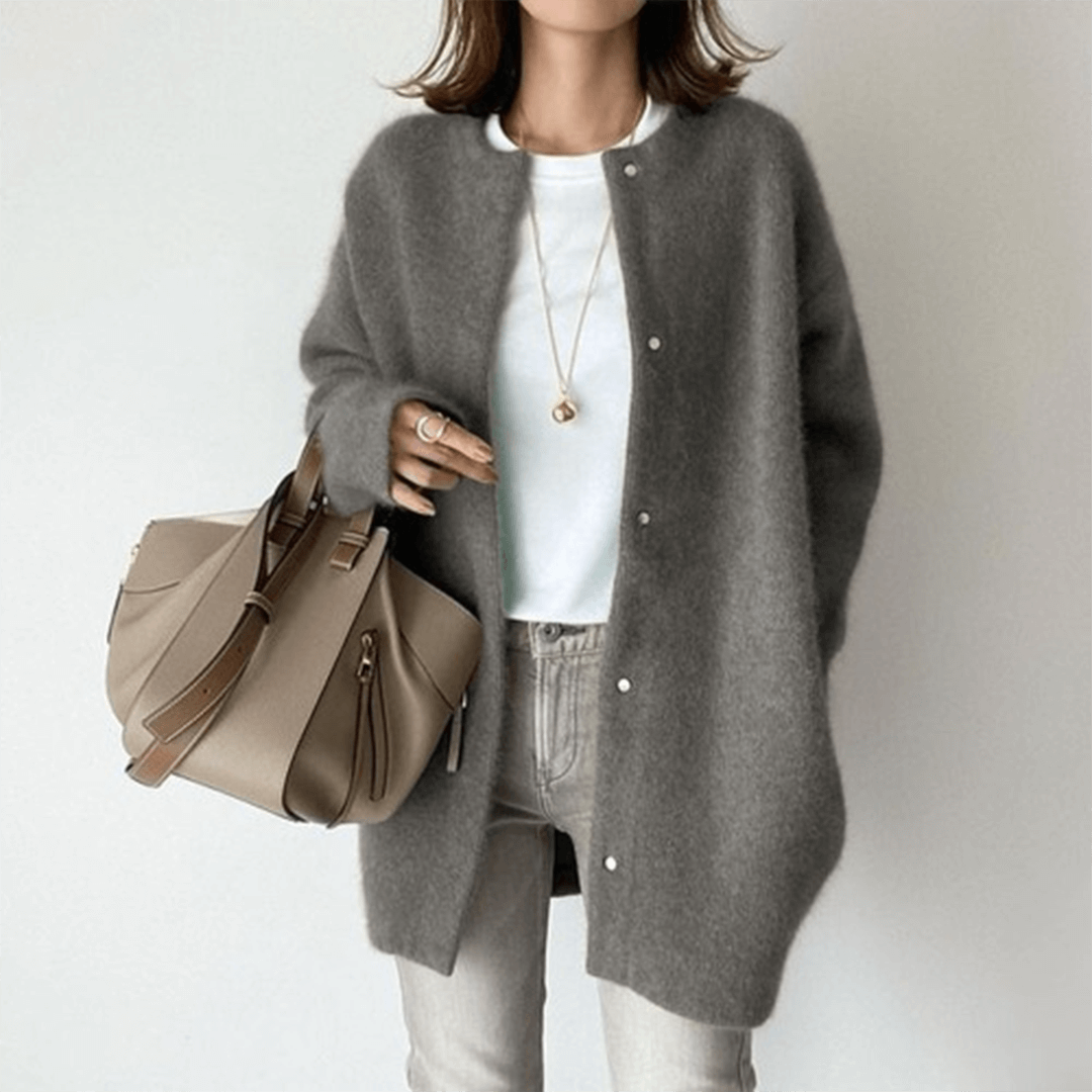Dame i lang strikket cardigan med rund hals og knaplukning