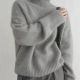 Dame i ensfarvet rullekravesweater med lange ærmer og ribkanter