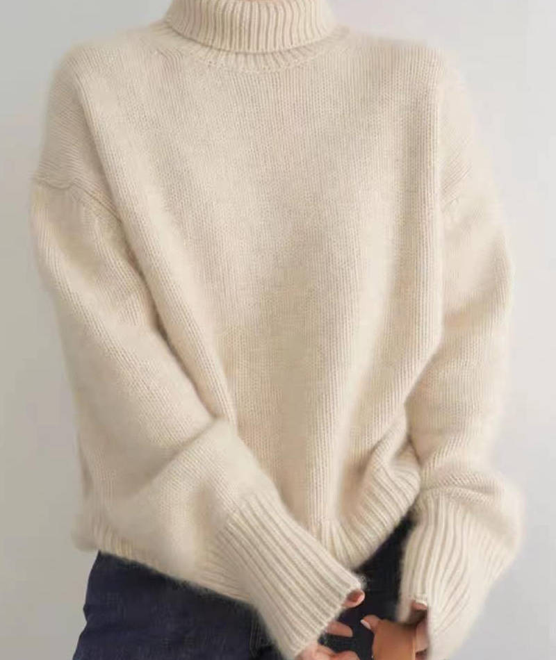 Dame i ensfarvet rullekravesweater med lange ærmer og ribkanter